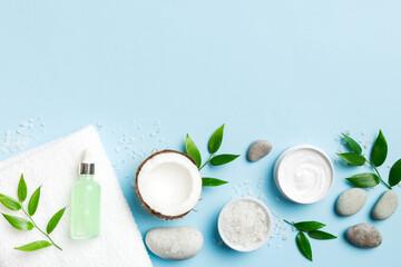 Coconut with jars of coconut oil and cosmetic cream on colored background. Top view. Free space for your text. Natural spa coconut cosmetics and organic treatment concept Coconut Spa composition