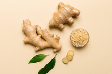 Finely dry Ginger powder in bowl with green leaves isolated on colored background. top view flat lay
