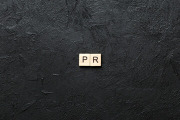 pr word written on wood block. public relation text on table, concept