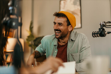 Energetic co-hosts sharing insights while recording their podcast in a modern space