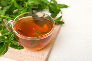 Cup of mint tea on table background. Green tea with fresh mint top view with copy space