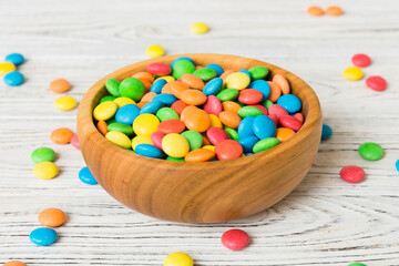 Multicolored candies in a bowl on a colored background. birthday and holiday concept. Top view with copy space