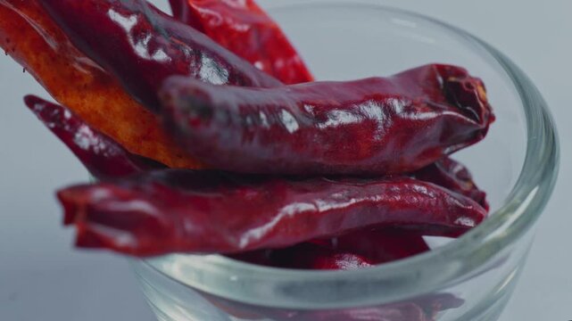 Dried red chilli or Sukhi lal mirch in small glass bowl, 4k, parallax shot.