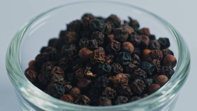 Black pepper or kali mirch in small glass bowl, 4k, parallax shot.