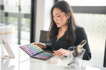 Asian girl makeup artist Professional Woman blogger vlogger is showing cosmetics products with...