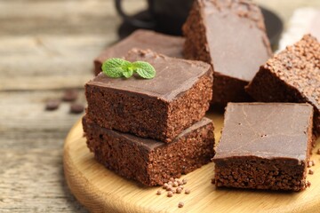 Delicious chocolate puffed rice bars and mint on wooden table, closeup