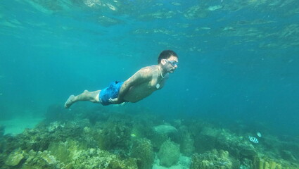 under water young man snorkeling on tailand