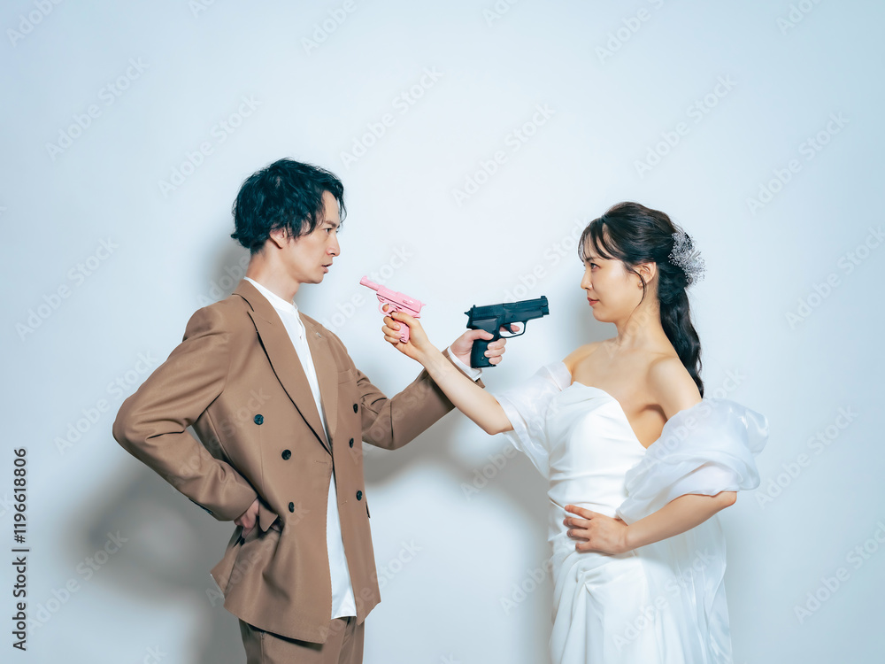 Leinwandbilder ウェディング、カップル、自撮り、新婦、新郎、ブライダル、対立、拳銃、ピストル、ドラマ、コミカル、刑事、ドレス、前撮り、フォーマル、パーティー、タキシード、エージェント、スパイ、カップルフォト、フォト、スタジオ、写真館、セルフ、結婚、婚活、パートナー、コピースペース、白バック、男女、女性、男性、日本人、映画、結婚式、笑顔、ウエディング、花嫁、チームワーク、サポート、マッチング、対決、喧嘩、口論、不満