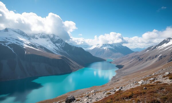 Turquoise lake with snow-capped mountains and white clouds
