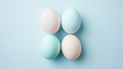 A simple arrangement of pastel-colored eggs on a light blue background, evoking a calm and festive atmosphere.