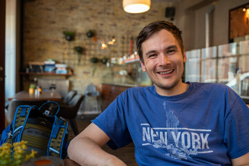 A man sitting in a cafe and smiling, having a good time
