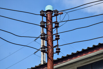 The photograph shows power poles and electric wires stretching across the sky.