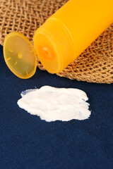 Spilled sunscreen from a yellow tube on clothes or towel. A dirty cosmetic stain on the fabric. The concept of daily stains on clothes