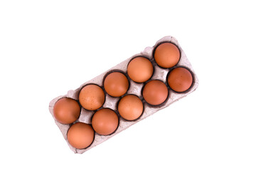 ten brown eggs in a tray, top view. for use in cooking articles, health promotions, or food...