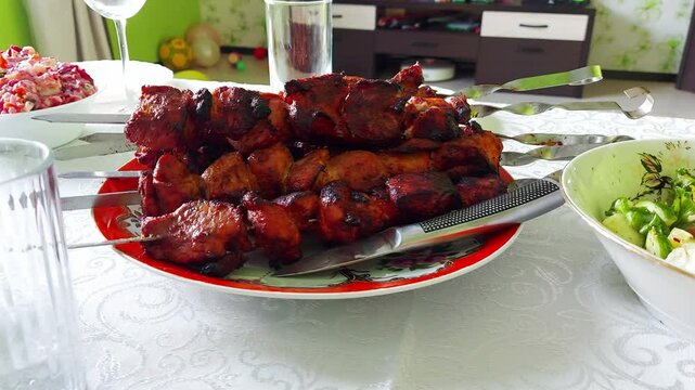 Fried meat shish kebab from pork in a plate on skewers on the table, close-up