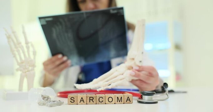 The doctor analyzes the patients foot Xray images to diagnose sarcoma using a skeletal model as reference