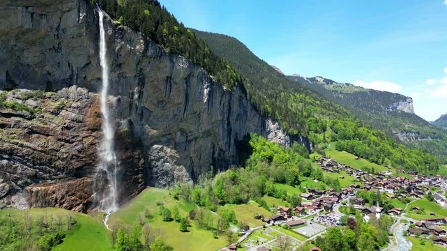 Descending aerial view of Lauterbrunnen and the Staubbachfall waterfalls, river and village. Lauterbrunnen, Switzerland.