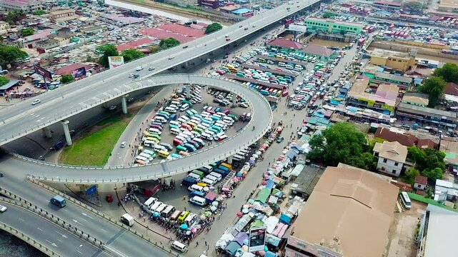 Aerial stock footage of the Kwame Nkrumah Interchange in Accra, Ghana formerly called Kwame Nkrumah Circle, with lots of cars parked on the base.
