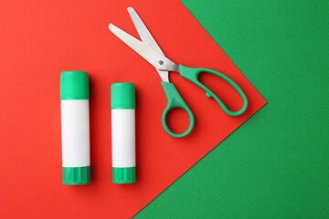 Glue and scissors on color background, flat lay