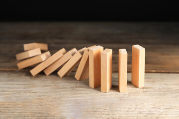 Domino effect. Wooden blocks falling on table