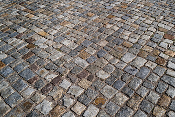 Background of bricks road. Background with bricks road. Stone cladding pavement. Brick surface background. Rough brick road. Stone pavement texture.