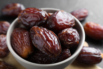 Tasty dried dates in bowl on table, closeup