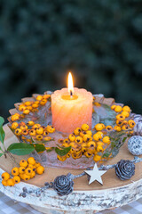 Winter-Arrangement mit einer Kerze und Eislaterne mit Feuerdornbeeren (Pyracantha)