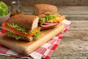 Delicious sandwiches with ham on wooden table, closeup