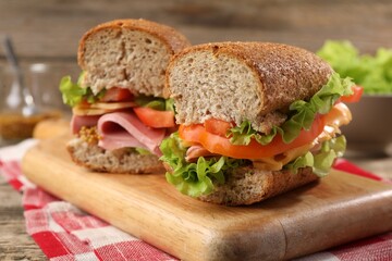 Delicious sandwiches with ham on wooden table, closeup