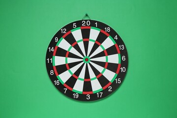 One dart board hanging on green wall