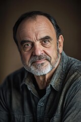 Obraz premium Portrait of mature man with beard and serious expression, showcasing wisdom and experience in professional setting, ideal for concepts of leadership and resilience.