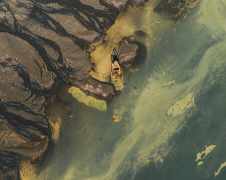 Aerial view of the Clyne Castle shipwreck resting in shallow waters, South Iceland.