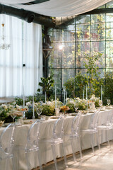 Modern stylish wedding table setting. The wedding decor. The pastel colors flowers bouquet. Natural beautiful wedding decorations. Minimalistic wedding decorations