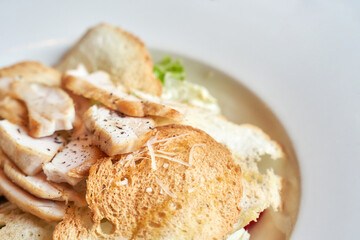 Close up of delicious chicken caesar salad with crispy croutons and shredded parmesan cheese.