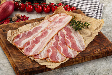 Sliced pork bacon over board
