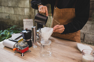 barista prepares pour-over coffee, pouring fresh grounds into a filter homemade brewing process...