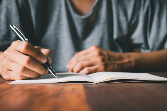  student writes in notebook, focusing on study homework, exam preparation. The moment learning and the pursuit of knowledge in an educational setting. Close up