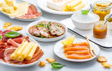 Assorted appetizers for brunch or party with salmon, cheese, salami and vegetables