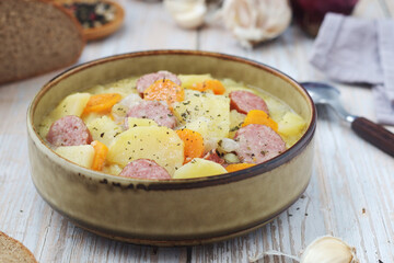 A bowl with traditional German potato soup with sausages