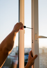 Hand of worker adjusting plastic window.