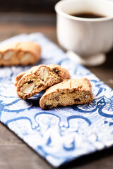 Cantuccini (Italian cookie) and a cup of coffee on dark wooden background. Close up.