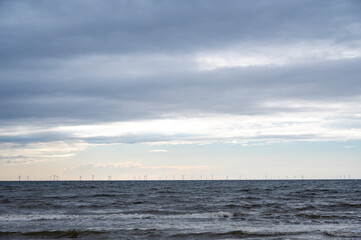 Sea with many wind turbines on the horizon