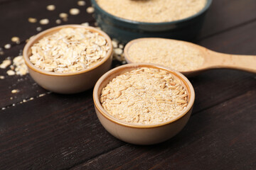 Oat bran, grains and flakes on wooden table, closeup