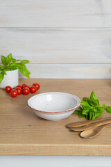 Ceramic salad and soup bowl on light wooden kitchen table
