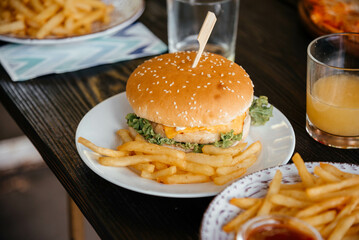 Close up of delicious cheese burger on plate with french fries. 