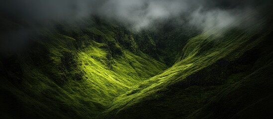 Sunlit green valley shrouded in mist.