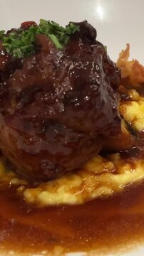 Delicious tender beef cheecks with creamy polenta and vegetables, fancy restaurant dining experience, 4K shot