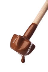 closeup of liquid chocolate dripping from a wooden querl isolated on white background