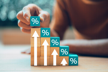 Hand-picked wooden blocks with percentage symbols and up arrows. Interest rates and dividends....