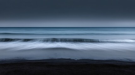 Obraz premium Serene ocean waves on a dark beach.